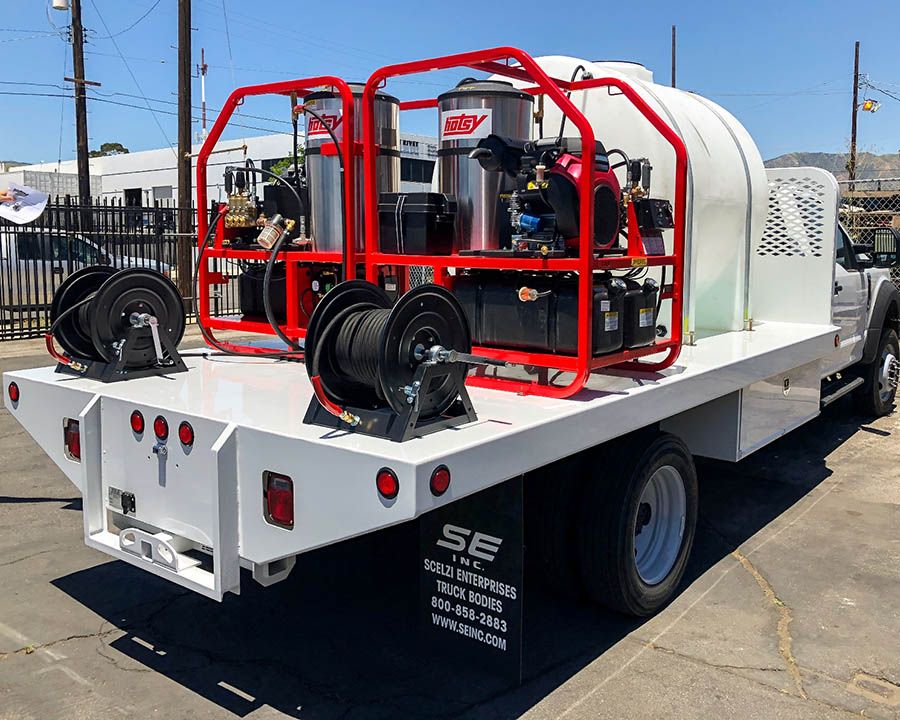 Two Hotsy hot water machines, two hose reels and a large tank on a white flatbed truck