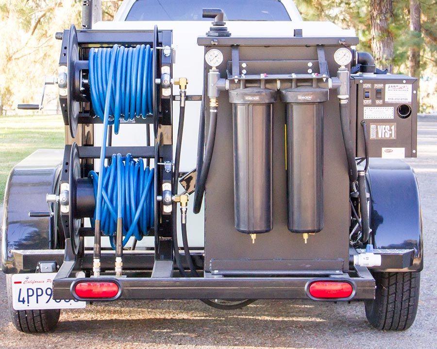 The rear of a trailer with a VFS-1 water filtration unit, two filter canisters and hose reels