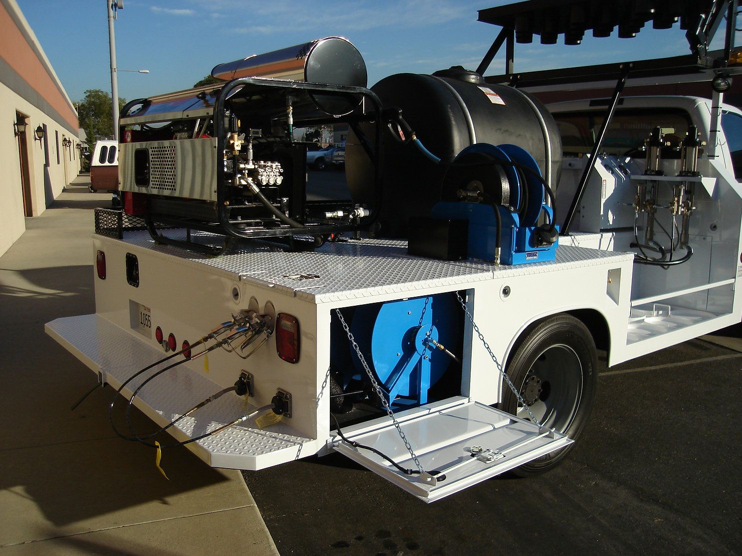 Bed of a Roadline graffiti-removal truck build: hot-water machine, tank and hose reels